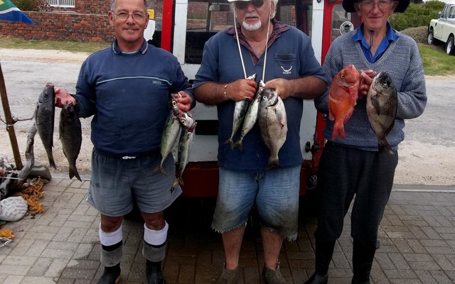 Dis gelukkige manne hierdie! Na ‘n lekker dag op see kan (van links) Steve Serbon, Johan Henn en Jannie Roux ook spog met makriel, mooi hotties en ‘n roman. 
